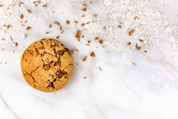 Chocolate chips cookie with flour on white marble