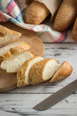 French baguette cut with a knife on cutting board