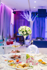 Served table with bouquet of flowers and blue illumination