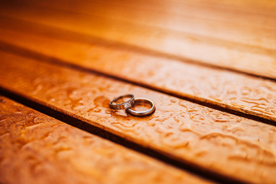 Gold wedding rings on a wooden background