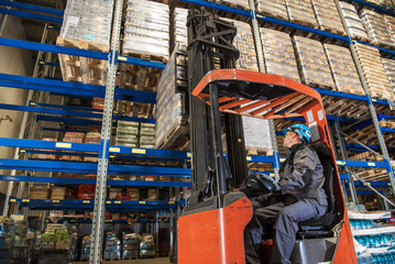 Storehouse employee during driving on forklift in warehouse © peterzayda