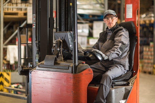 Caucasian Fork Lift Truck Driver Waiting For Delivery.