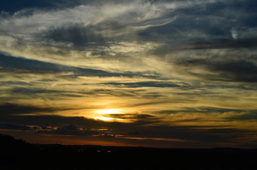 blue sky with colors while and orange with beautiful training of clouds in the for the sun