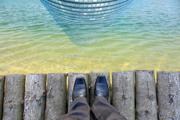Nogi w butach na kładce nad jeziorem, Sky Tower.