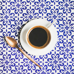 Cup of black Turkish or Eastern style coffee over oriental Moroccan patterned background, top view, square crop