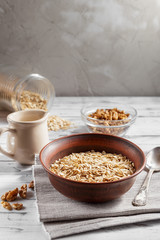 Oat flakes in brown clay bowl ready to cook