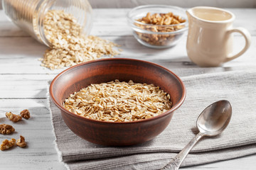 Oat flakes in brown clay bowl ready to cook