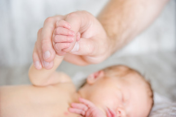 Father holding a newborn baby's hand