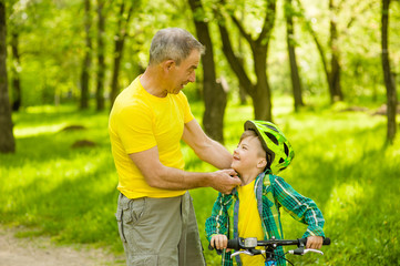 Father wears a bicycle helmet to his son