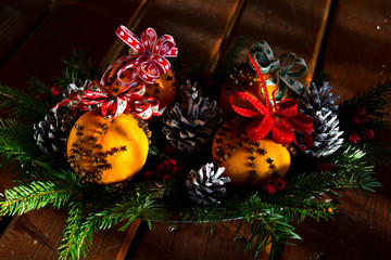 Fototapeta na wymiar christmas decoration - oranges and cones with red ribbons