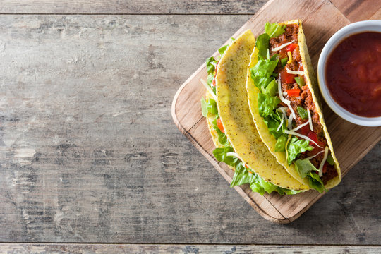 Mexican tacos on wooden background

