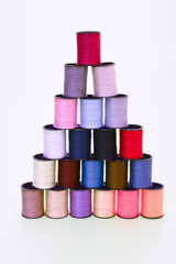 Coils with multi-colored threads made up in a pyramid on a white background
