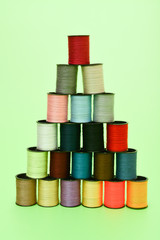 Coils with multi-colored threads made up in a pyramid on a green background