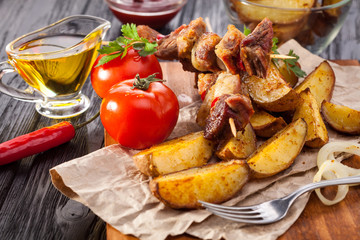Meat skewer with herbs With onions, baked potatoes, tomatoes and greens