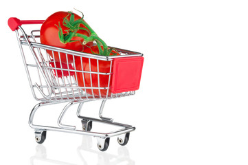 Fresh tomatoes in shopping cart on white background