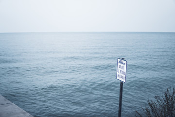 Do not stand beyond this point sign by the lake Ontario, NY