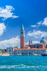 Venice landmark, view from sea of Piazza San Marco or st Mark square, Campanile and Ducale or Doge Palace with colorful blue sky and white clouds. Italy, Europe.