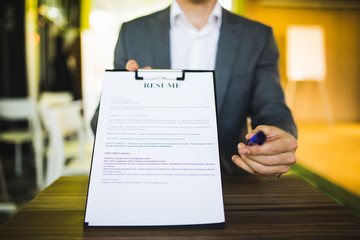 Young businessman submitting resume to employer to review