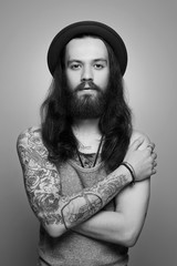 tattooed handsome bearded man in hat