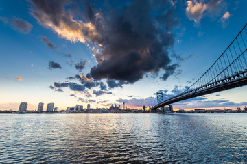 Obraz premium sunset skyline of philadelphia pennsylvania from camden new jersey with benjamin franklin bridge