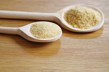 Organic brow sugar in a wooden spoon with copy space.