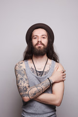Obraz premium handsome bearded man in hat.tattoo.hipster
