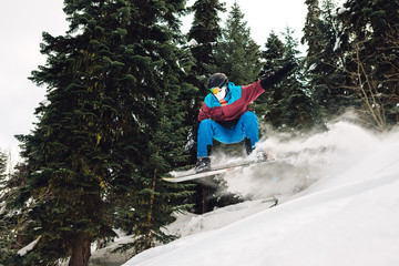 snowboarder is jumping and freeriding in the mountain forest