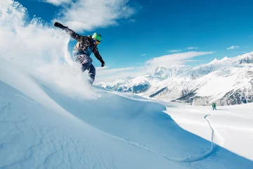 Fotobehang Wintersport snowboarder rijdt vanaf de berg