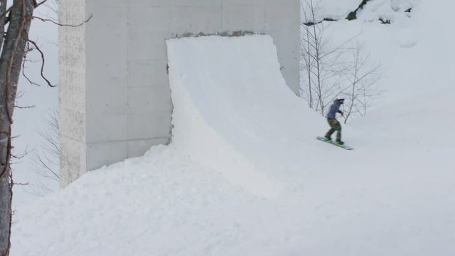 Snowboarder Freestyle Tricks Jumping on a Wall Quarterpipe