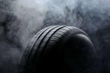 Car tire and smoke on black background - obrazy, fototapety, plakaty