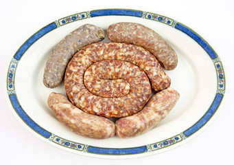 Looks unpleasant but tastes delicious: plate filled with assorted types of sausages. Isolated.