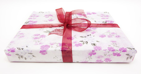 Pink and white wrapped gift with red ribbon. Isolated.