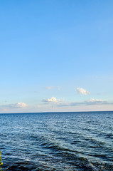 Fototapeta premium Beautiful sea, river, lake, reservoir. Ukraine, Dnepropetrovsk region, Nikopol city. Natural panorama in the rays of the setting, the rising sun. A magnificent blue sky with neat clouds. 