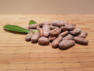 Kakaobohnen mit Blatt auf Bambusbrett