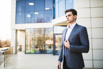 Fototapeta premium Handsome business man outdoors in front of office building