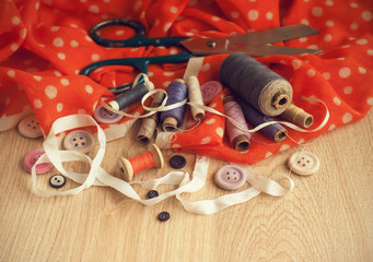 Old scissors, spools of thread, buttons and ribbons in vintage style.