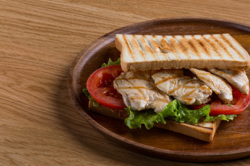Sandwich with chicken, vegetables, tomato, cheese and sauce. 