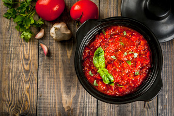 Basic Italian tomato sauce marinara for pasta. In a saucepot pan with ingredients on a wooden...