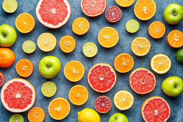 Citrus fruit pattern on grey concrete table. Food background. Healthy eating. Antioxidant, detox, dieting, clean eating, vegetarian, vegan, fitness or healthy lifestyle concept