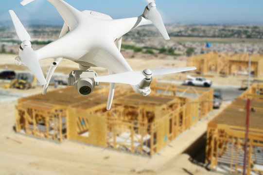 Unmanned Aircraft System (UAV) Quadcopter Drone In The Air Over Construction Site.