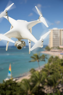 Unmanned Aircraft System (UAV) Quadcopter Drone In The Air Over Waikiki Beach In Hawaii.
