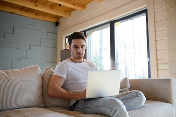 Man on sofa using gadget