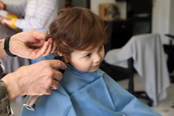 little kid cutting the hair in the barbershop