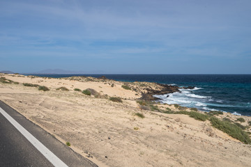 Yellow sand and black stones on the volcanic coastline