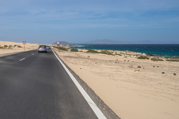Fototapeta na wymiar The asphalt road through the sand dunes in Canarian Island