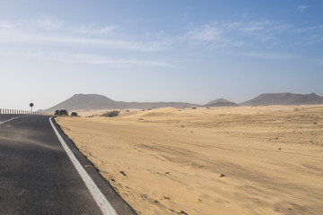 Fototapeta na wymiar The asphalt road through the sand dunes in Canarian Island