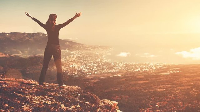Young woman stand on top of mountain with raised hands in sunset soft light. Majestic nature landscape. Beauty world, sport lifestyle, holidays, travel and recreation. Vintage toning. Slow motion 4K