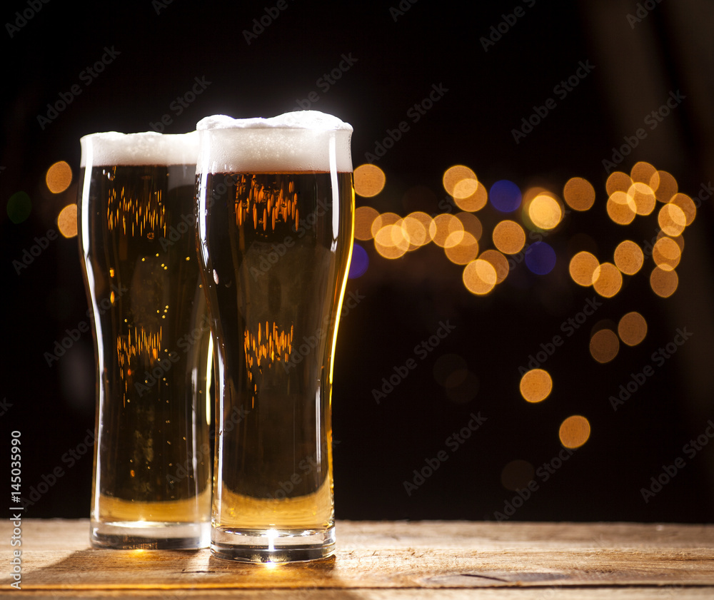 Wall mural two glasses of beer on bar lights background