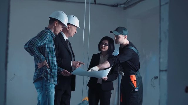 The development group of a project standing and discussing the plan on a site hand shaking then turn on camera and looking straight and snile