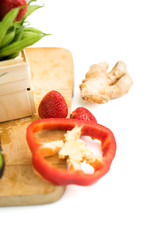 A wooden cooking board with veggies isolated on white